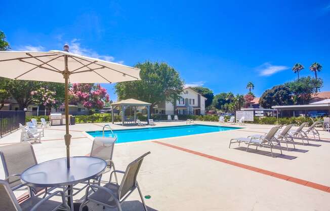 a swimming pool with chairs and tables and umbrellas