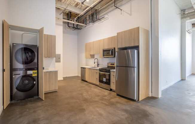 Santa Fe Art Colony kitchen with a washing machine and a stainless steel refrigerator