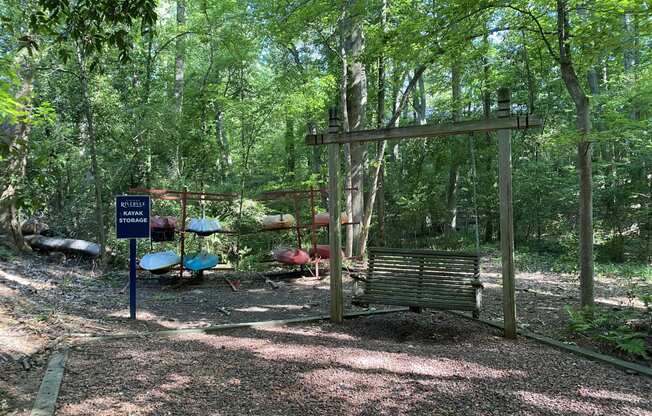 a swing set in the middle of a wooded area