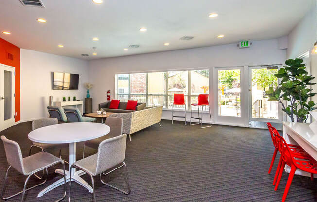 a lounge area with chairs and tables and windows at Skyview Apartments, Westminster, CO 