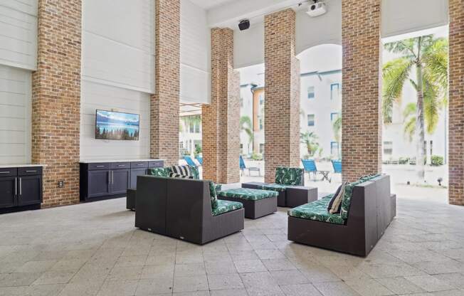 the lobby of a hotel with seating and a television