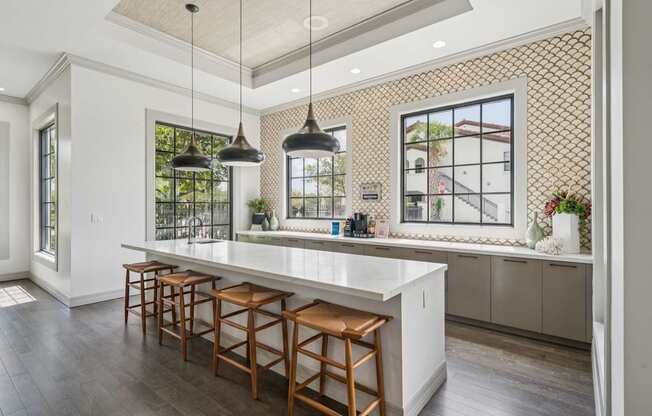 A kitchen with a white counter and wooden bar stools.