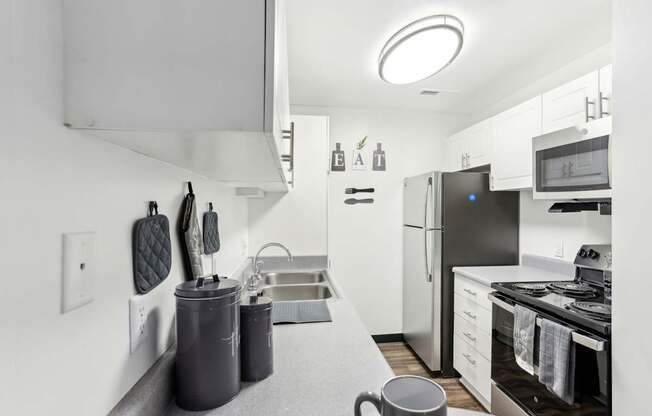 A modern kitchen with a grey countertop and stainless steel appliances.