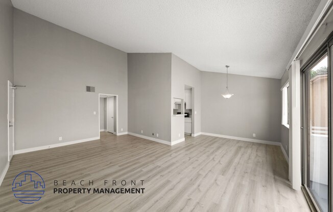 the living room and dining room with wood flooring and a large window