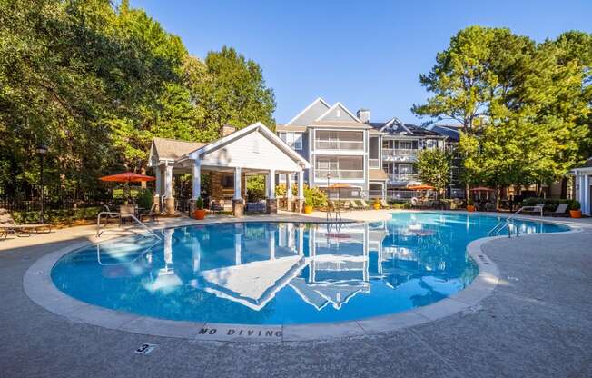 a large pool with a house in the background