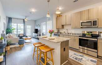 A kitchen with a bar stool in front of a counter.