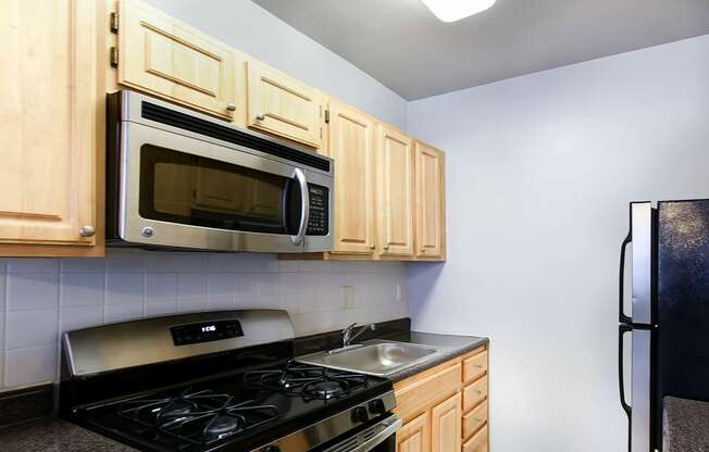 A kitchen with wooden cabinets and a black stove top.