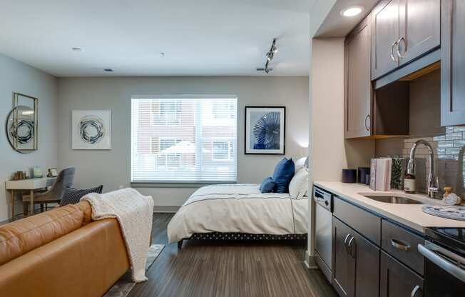 a bedroom with a bed and a kitchen with a sink