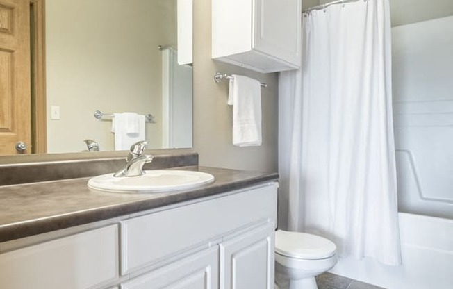 Bathroom with white cabinetry and bathtub at Stone Ridge townhomes in south Lincoln NE