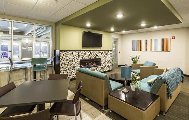 a lobby with couches chairs and tables and a fireplace