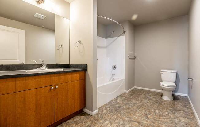 A bathroom with a toilet, sink, and mirror.