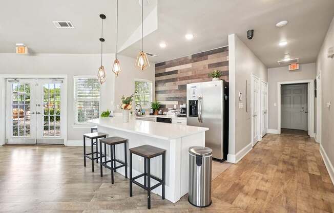 A kitchen with a white counter and bar stools.