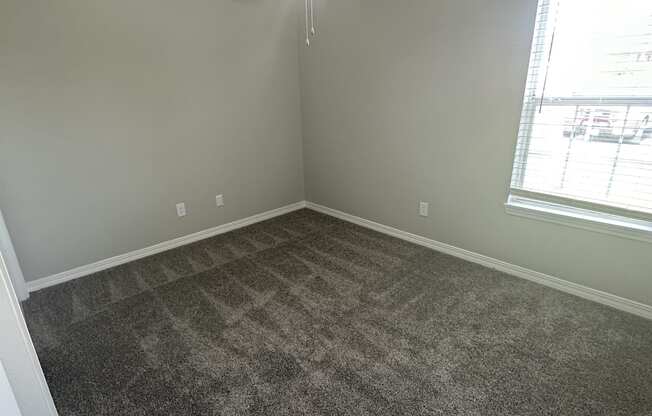 an empty room with a ceiling fan and a window