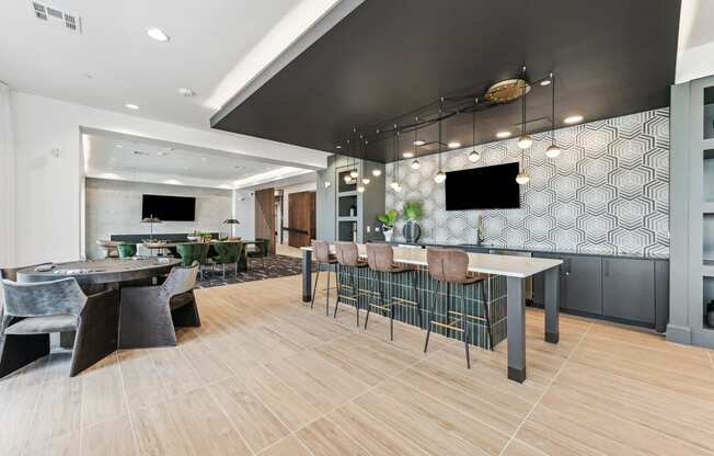 a lobby with tables and chairs and a bar and a television
