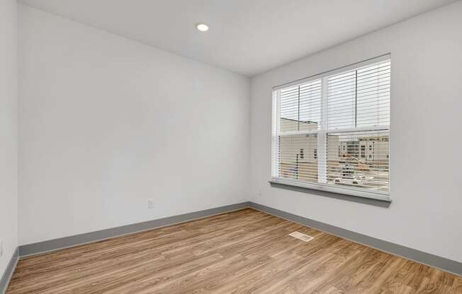 an empty room with wood flooring and a large window at Meridian at CityPlace, Woodbury, MN 55125