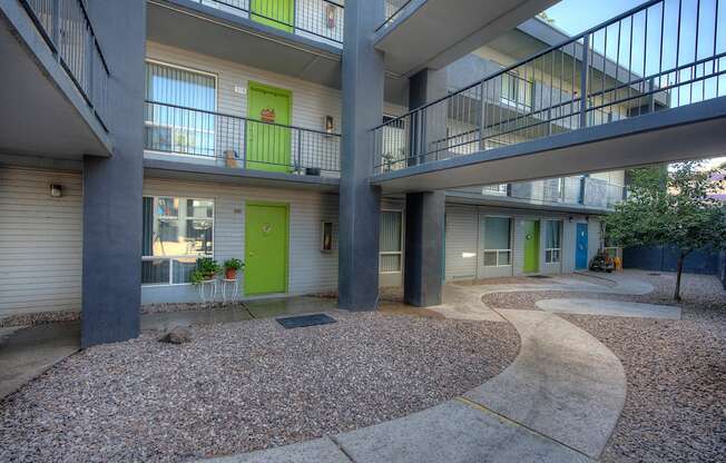 the courtyard of a building with two balconies and a green door