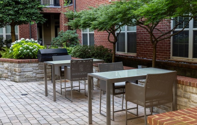 a patio with tables and chairs outside of a brick building