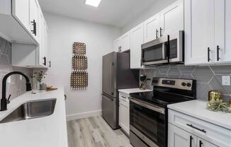 a kitchen with stainless steel appliances and white cabinets