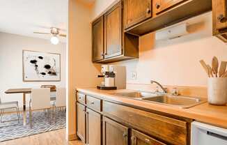 A kitchen with wooden cabinets and a painting of a Dalmatian dog on the wall.