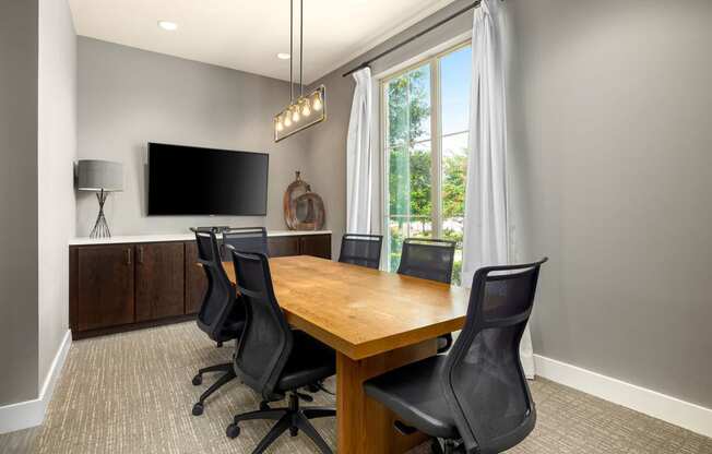 a conference room with a wooden table and chairs and a tv