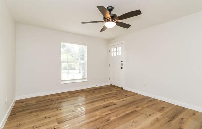 a bedroom with hardwood floors and a ceiling fan