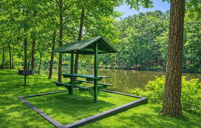 A picnic table is surrounded by a fence in a grassy area.