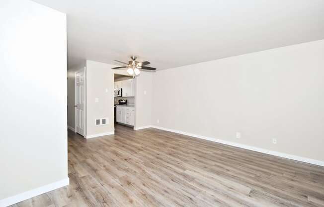 an empty living room with white walls and wood floors