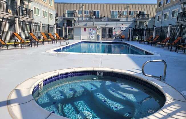 a hot tub is next to a pool in an apartment building