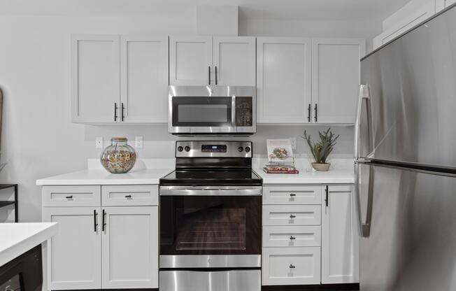 a kitchen with white cabinets and stainless steel appliances