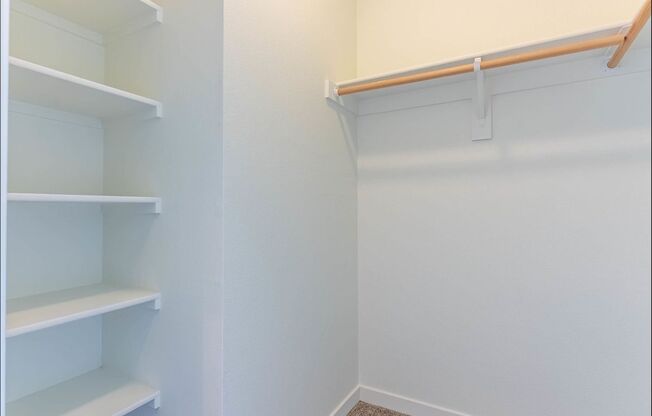 A white pantry with shelves and a white wall at Riverplace Apartment Homes, Independence, OR, 97351