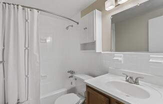 a white bathroom with a shower sink and toilet