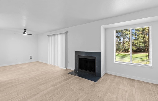 an empty living room with a fireplace and a window