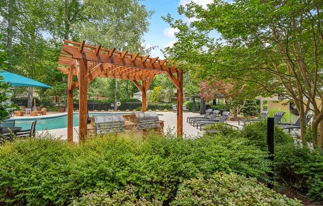 a patio with a wooden pergola and a swimming pool