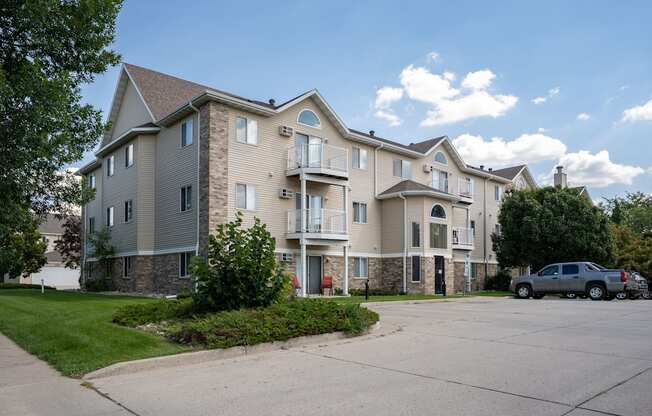 A large apartment complex with a parking lot in front.