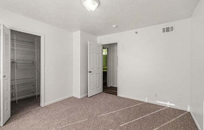 A room with a carpeted floor and a door on the left.