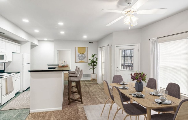 a dining room and kitchen with a table and chairs