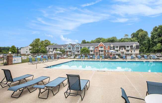 A pool with sun loungers and an apartment building in the background at Apple Ridge Apartments, Michigan, 49534