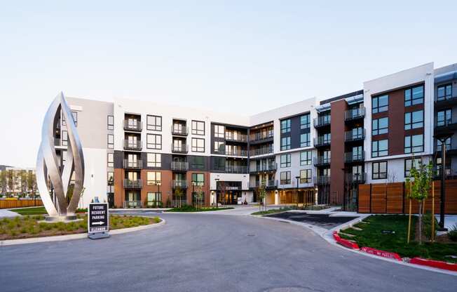 a street view of an apartment complex with a monument in the middle