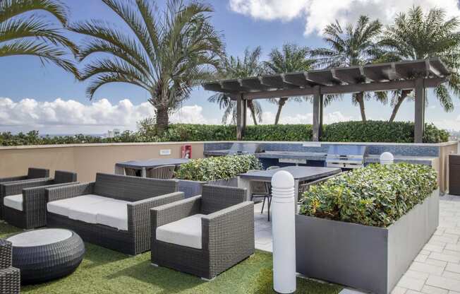 a terrace with tables and chairs and a gazebo and palm trees