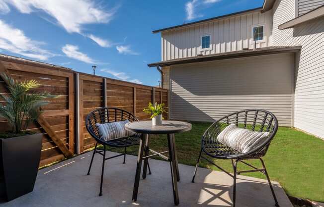 a patio with two chairs and a table on a patio