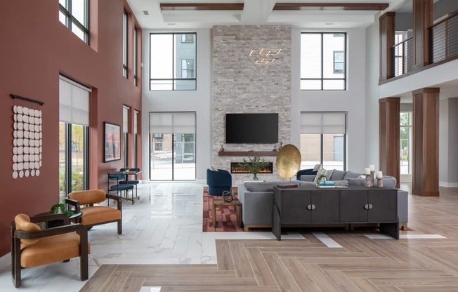 A modern living room with a stone fireplace and a large grey sofa.