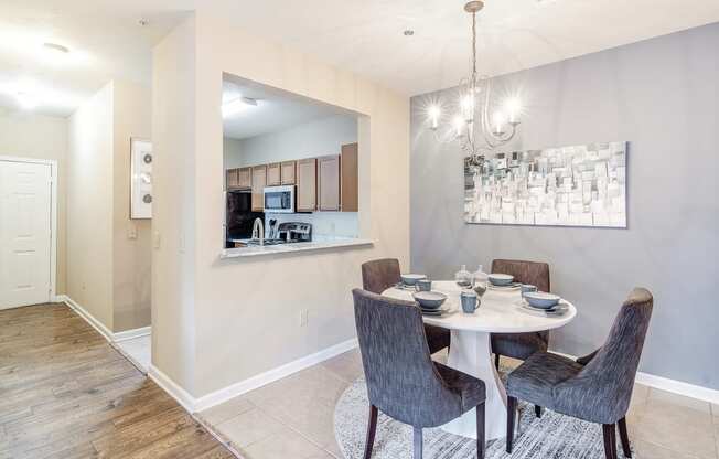 a dining area with a table and chairs and a kitchen at Vineyard of Olive Branch in Olive Branch, MS