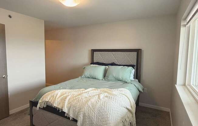 A bedroom with a bed, pillows, and a blanket.