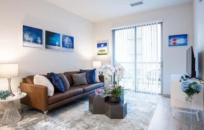 A living room with a brown couch, a coffee table, and a television.