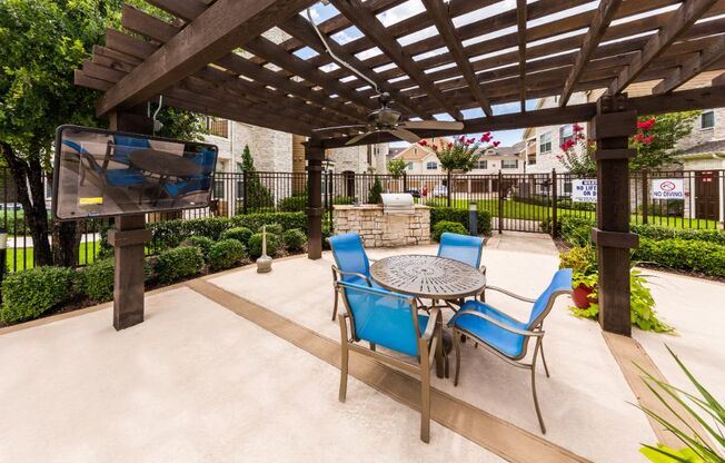 a patio with a table and chairs and a tv