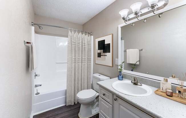 A bathroom with a toilet, sink, and shower.