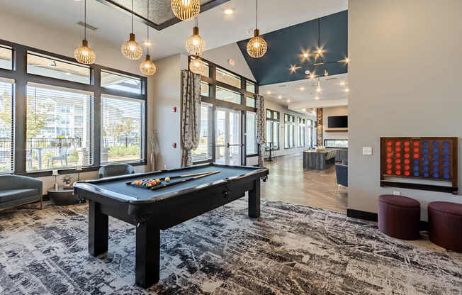 A billiard table is in the middle of a room with a black and white rug.