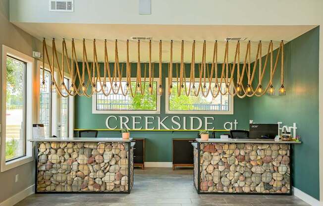 A reception area with a green wall and a sign that says CREEKSIDE at the top.