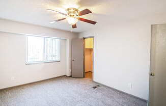 A room with a ceiling fan and a door.