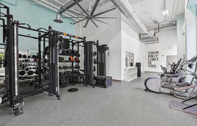 A gym with a sign that says "your only limit" on the wall.